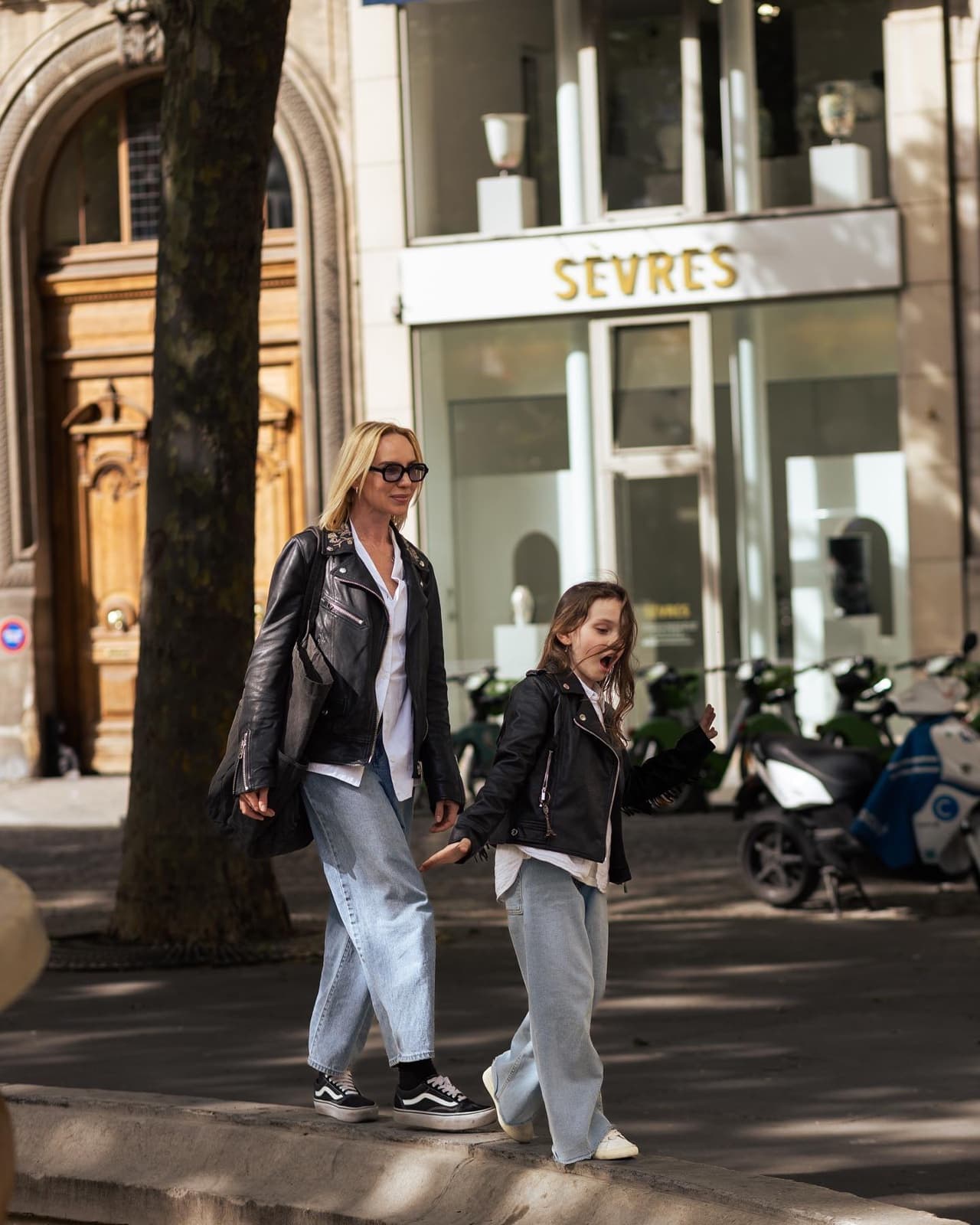 Mother and daughter walking hand in hand along a chic Paris street during a family session by SabShots