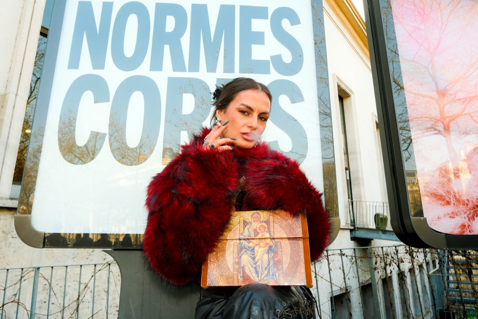 Fashion model in a red fur coat outside a Paris gallery, editorial street photography by SabShots
