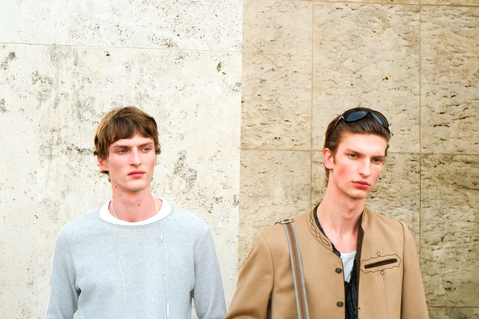 Two male fashion models in tailored knitwear against a textured Paris wall, menswear street photography by SabShots