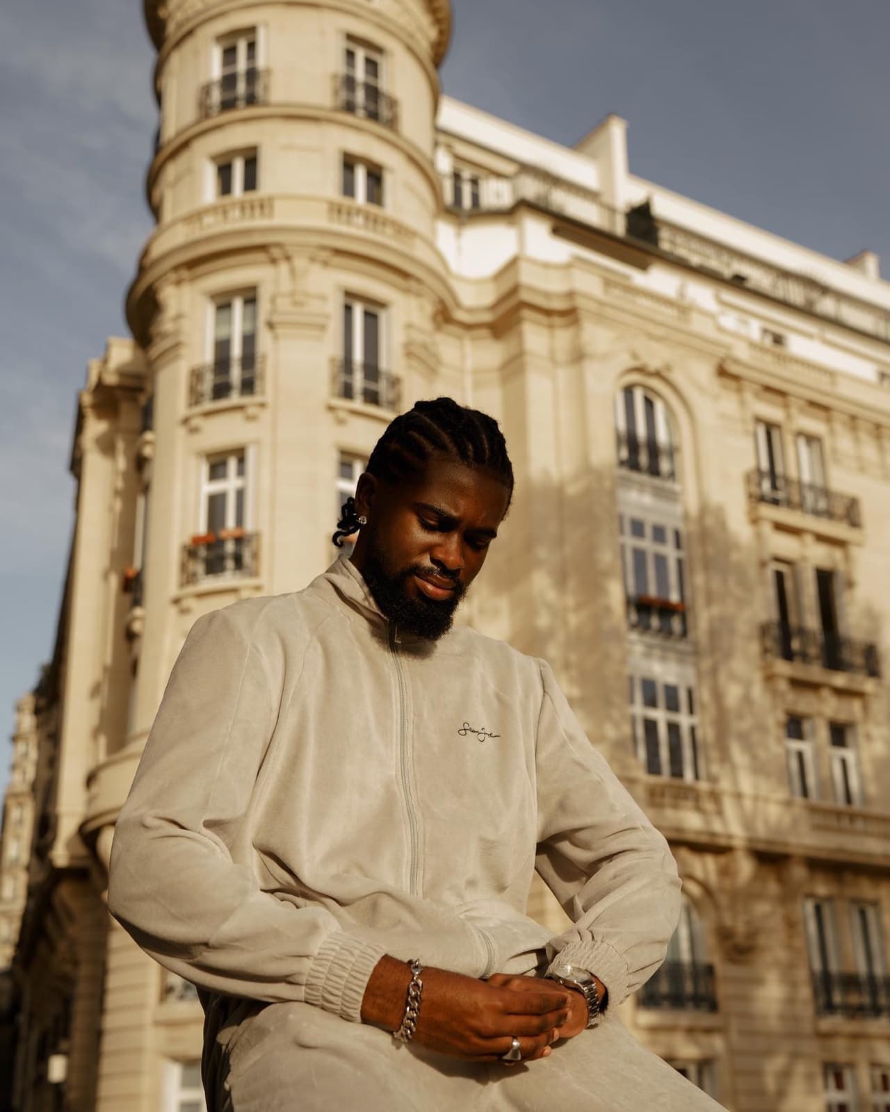 Man in a beige tracksuit before a Haussmann facade in Paris, contemporary street style photography by SabShots
