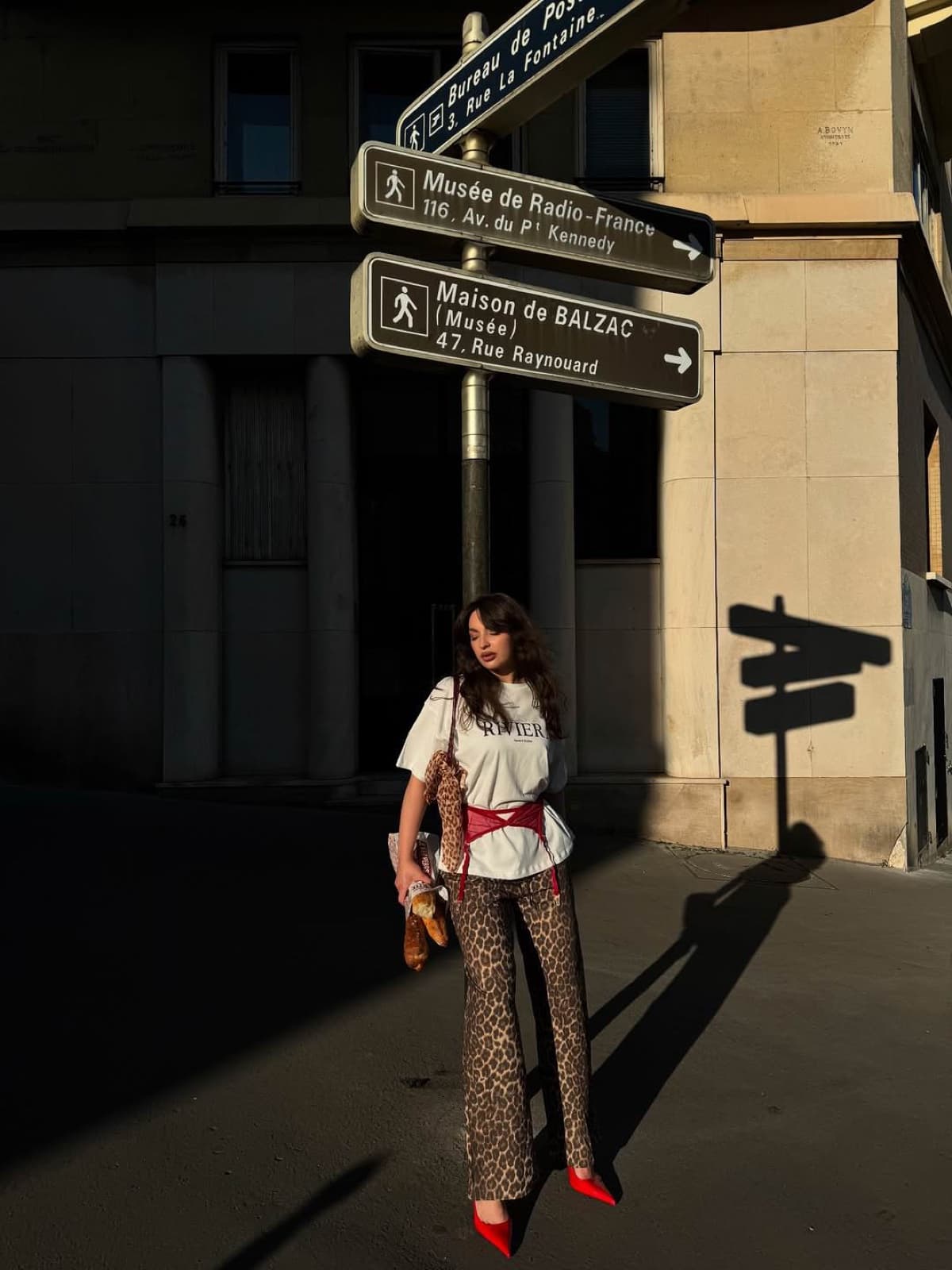 Woman in leopard trousers and red heels by Paris street signs, candid lifestyle street photography by SabShots