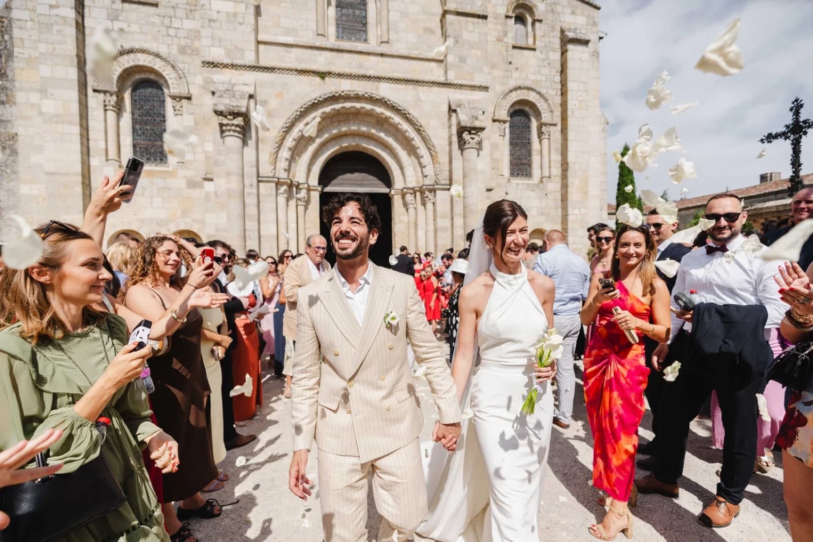 Joyful newlyweds under a white dove release outside a church at a Paris wedding by SabShots