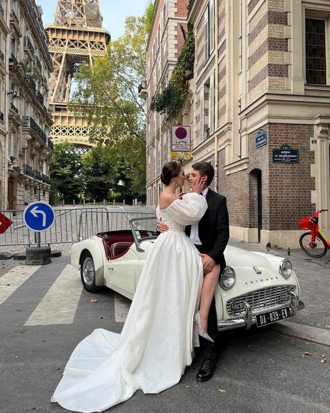 Couple kissing beside a vintage car near the Eiffel Tower at a Paris wedding by SabShots