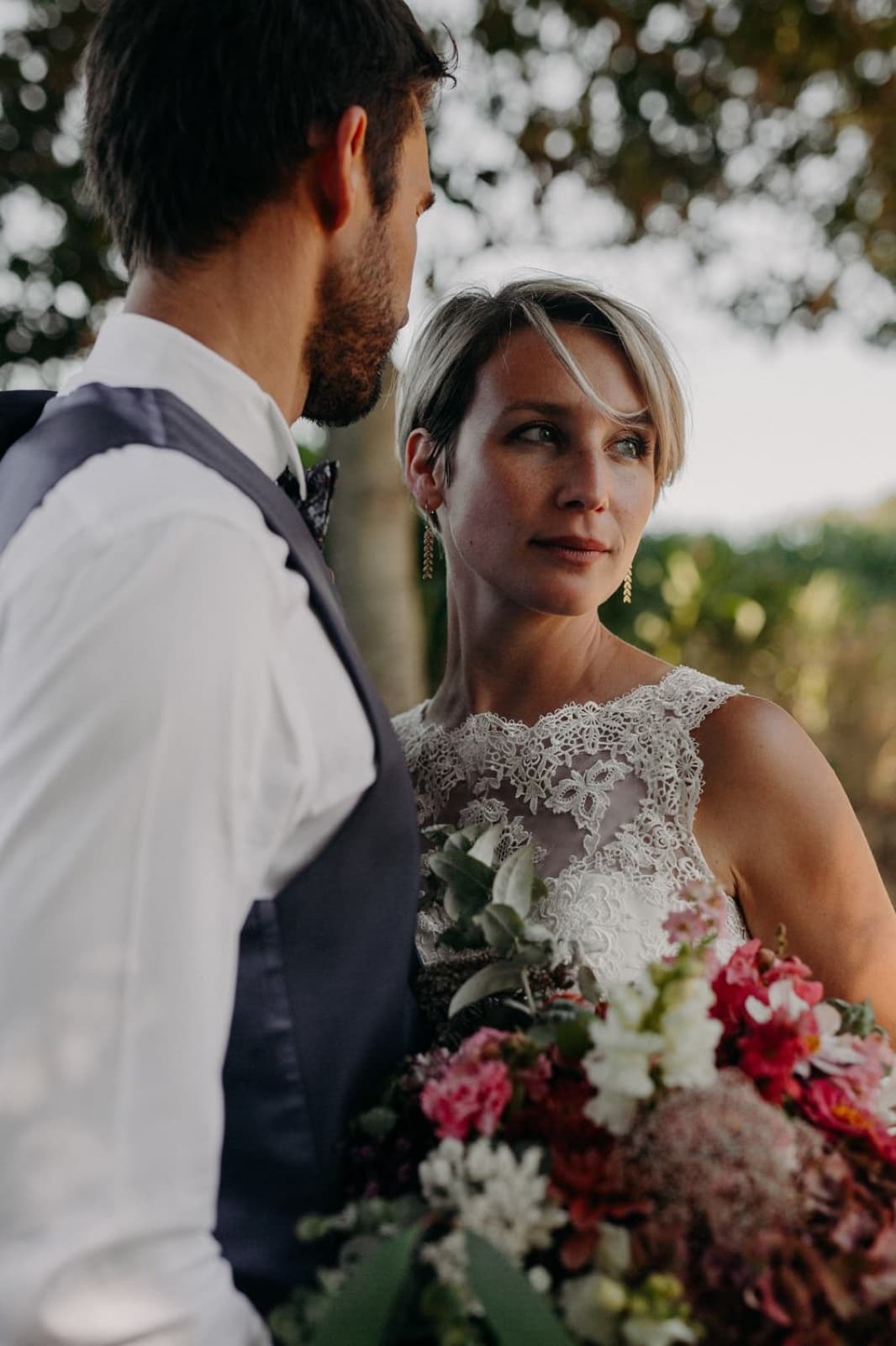 Bride holding a colorful bouquet beside her groom at a Paris wedding by SabShots