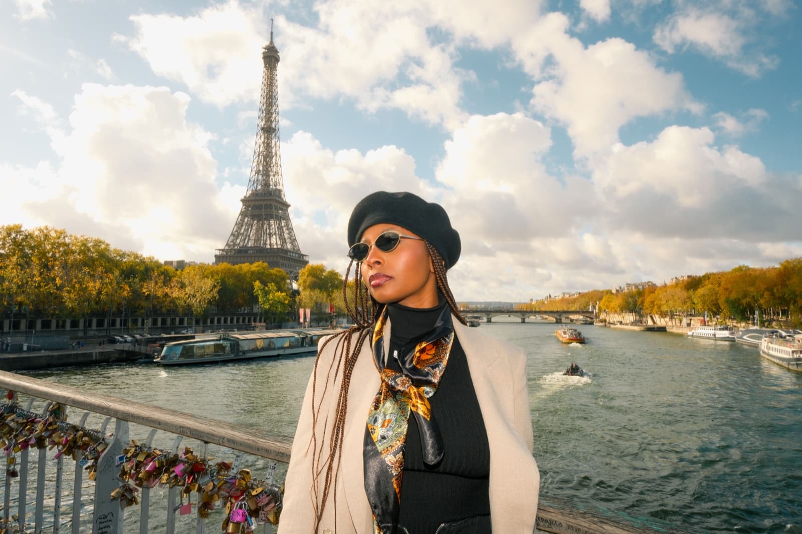 Stylish woman in a beret on a love-lock bridge over the Seine with the Eiffel Tower at golden hour in Paris by SabShots