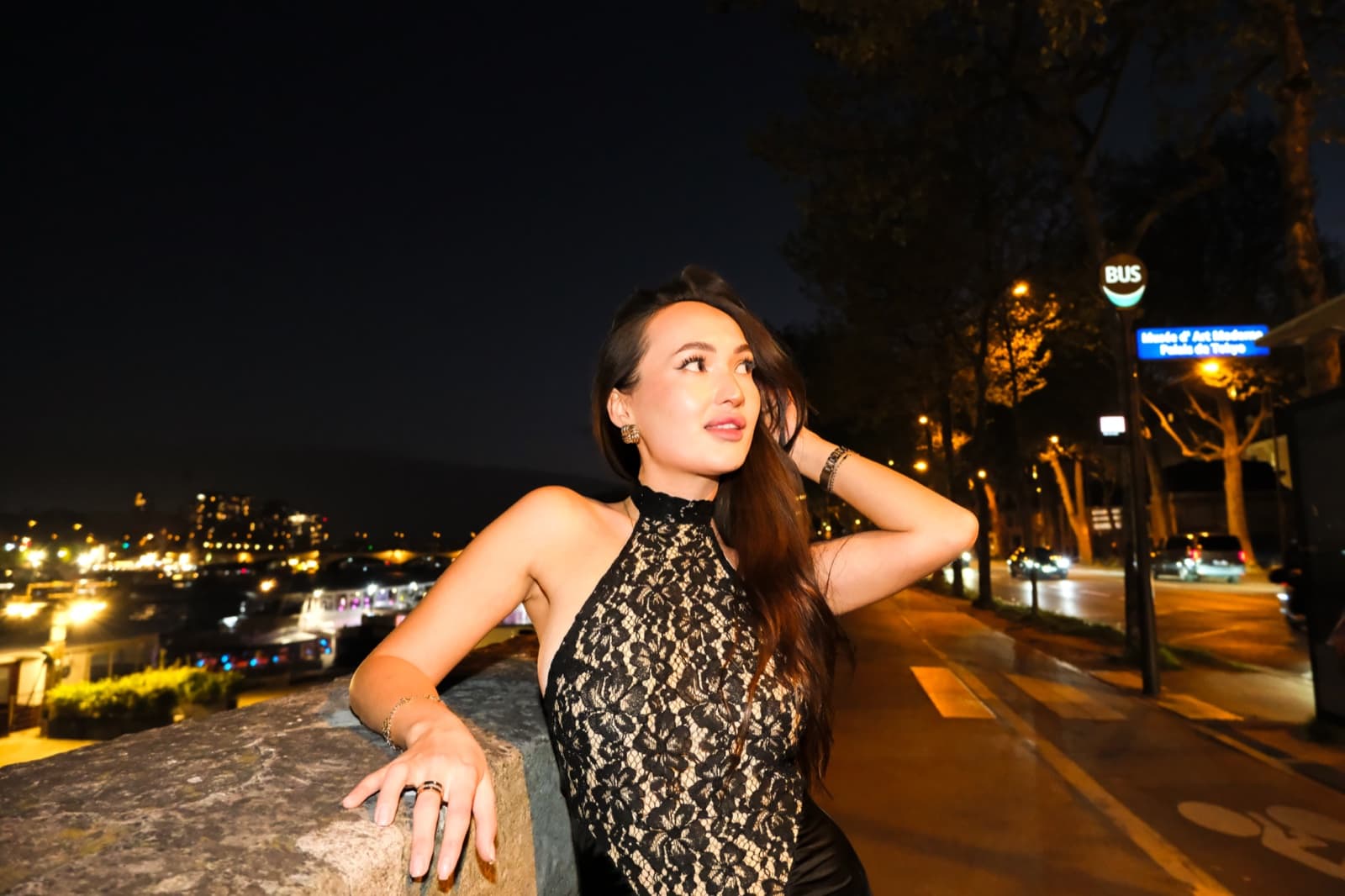 Woman in a black lace dress overlooking the Seine city lights at night, a romantic instagrammable Paris view by SabShots
