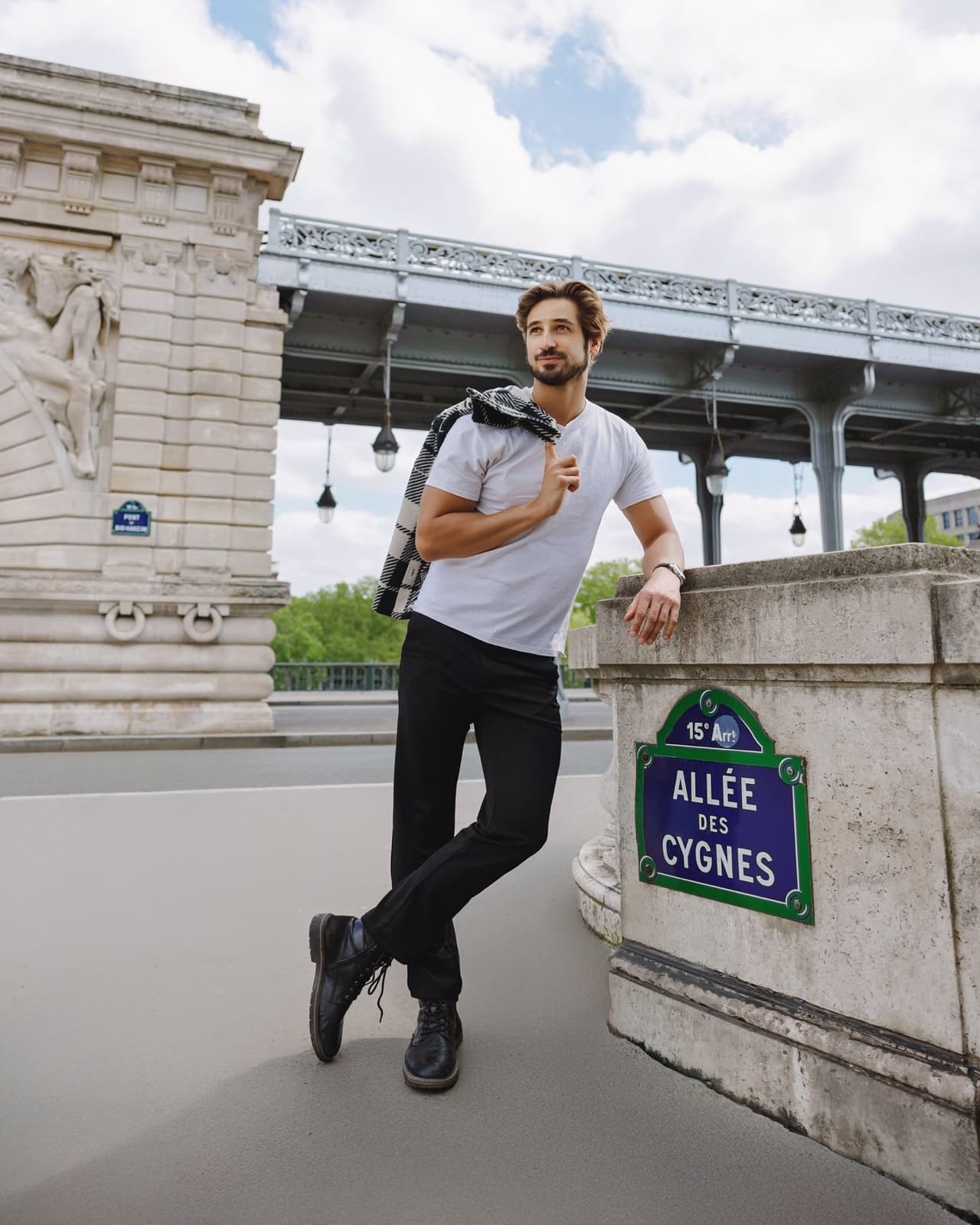 Man leaning by the Allee des Cygnes sign on the Pont de Bir-Hakeim, an instagrammable Paris spot by SabShots