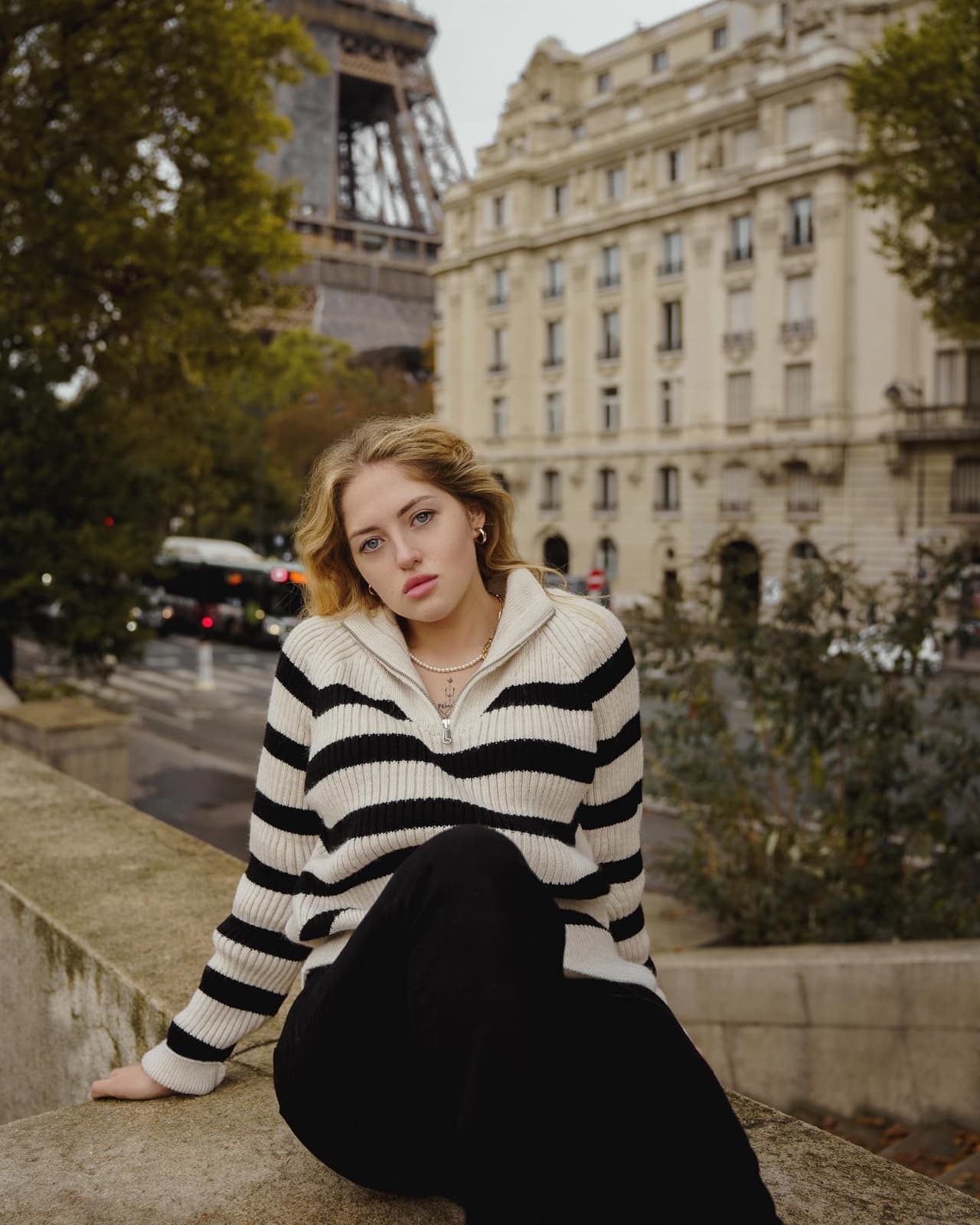 Woman in a striped sweater with the Eiffel Tower behind, a classic instagrammable Paris portrait by SabShots