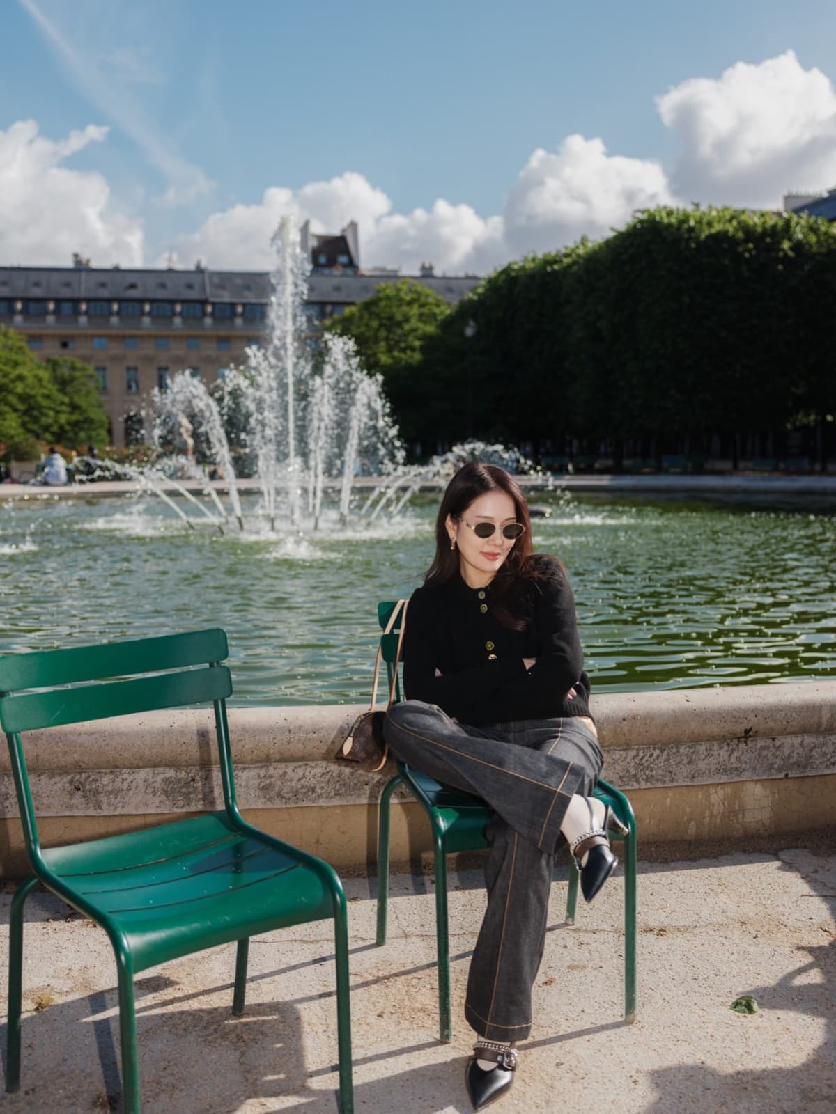 Woman on a green chair by a fountain in the Palais-Royal garden, an instagrammable Paris classic by SabShots