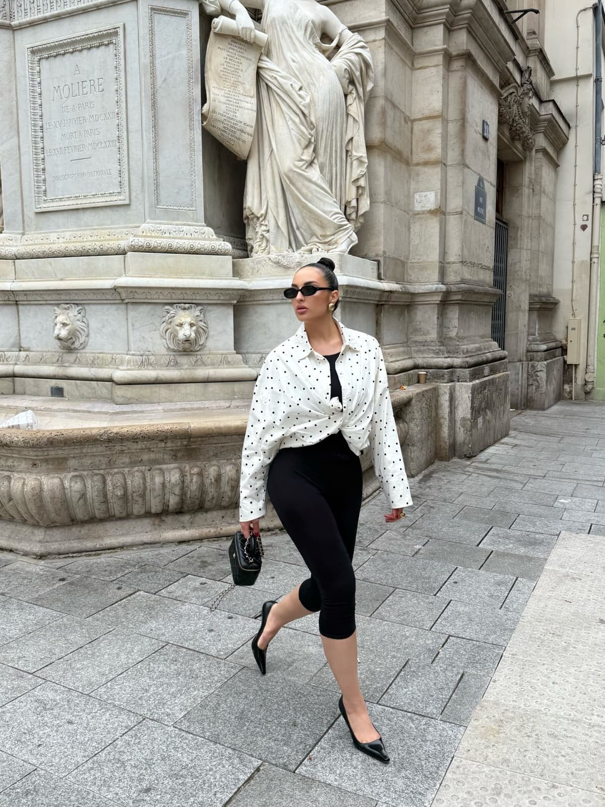 Woman striding past a marble fountain in Paris, a dynamic instagrammable photo moment by SabShots