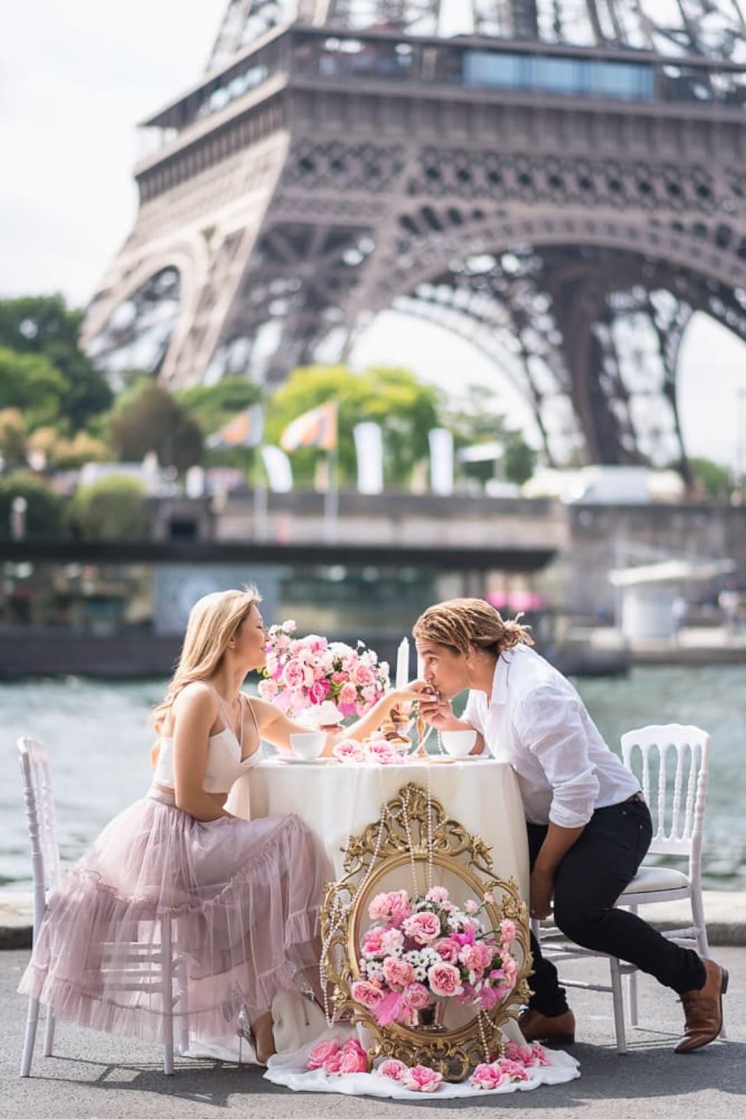 Couple at a candlelit tablescape with roses by the Seine facing the Eiffel Tower, a romantic Paris proposal by SabShots