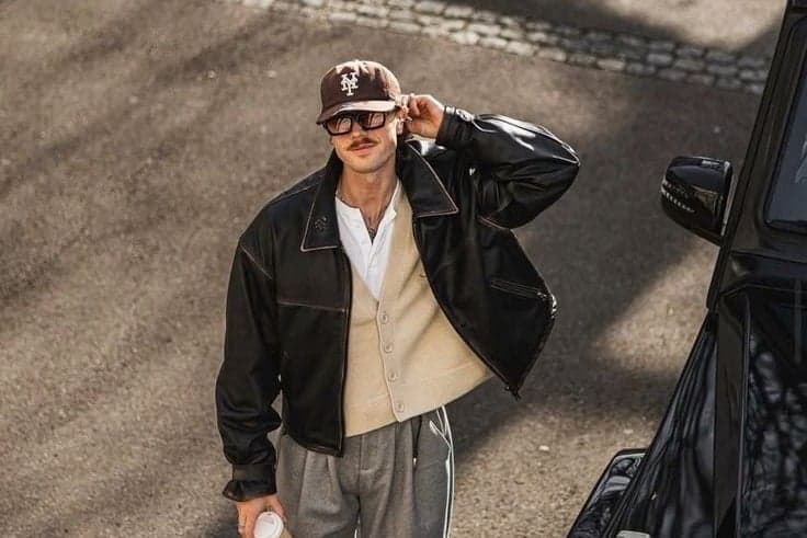Man in a baseball cap and black leather jacket holding coffee in Paris, lifestyle street photography by SabShots
