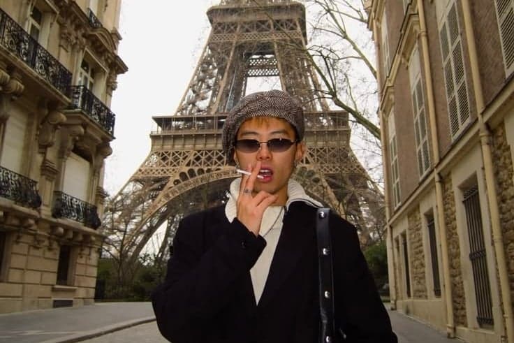 Man in a tweed cap and black coat beneath the Eiffel Tower, vintage photoshoot in Paris by SabShots