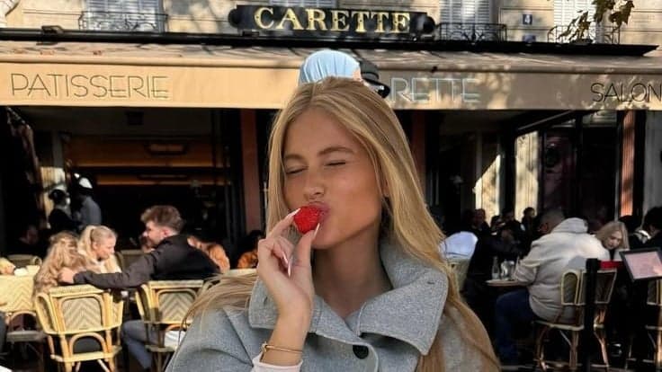 Woman eating a strawberry at the Carette cafe terrace, one of the best photo spots in Paris by SabShots