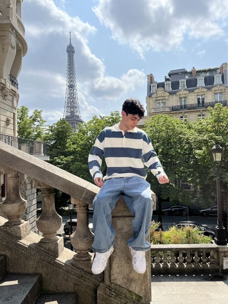 Man in a striped rugby shirt perched on a balustrade, Eiffel Tower photo session in Paris by SabShots