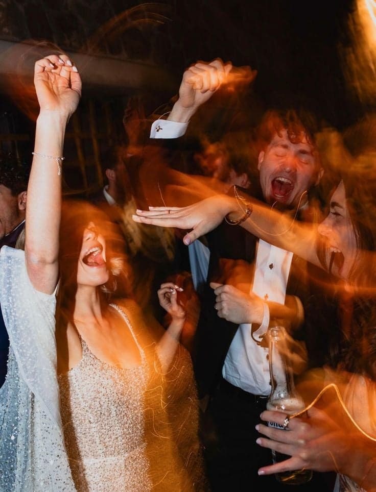 Dancers in sequins and tuxedo cheering through motion-blurred lights, Paris nightlife photography by SabShots
