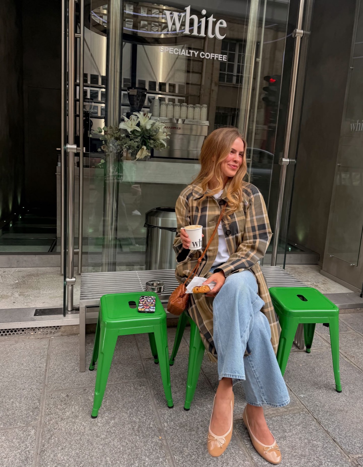 Woman on green stools outside a specialty coffee shop, a cozy instagrammable Paris cafe scene by SabShots