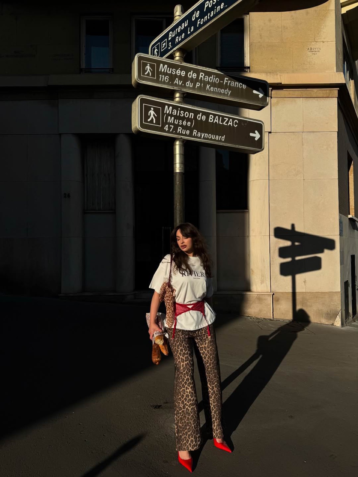 Woman in leopard trousers and red heels by Paris street signs, a bold solo photoshoot look by SabShots